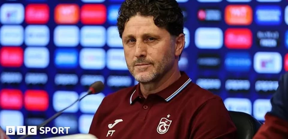 Football manager at press conference podium