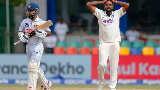 Batsman playing shot while bowler reacts in frustration