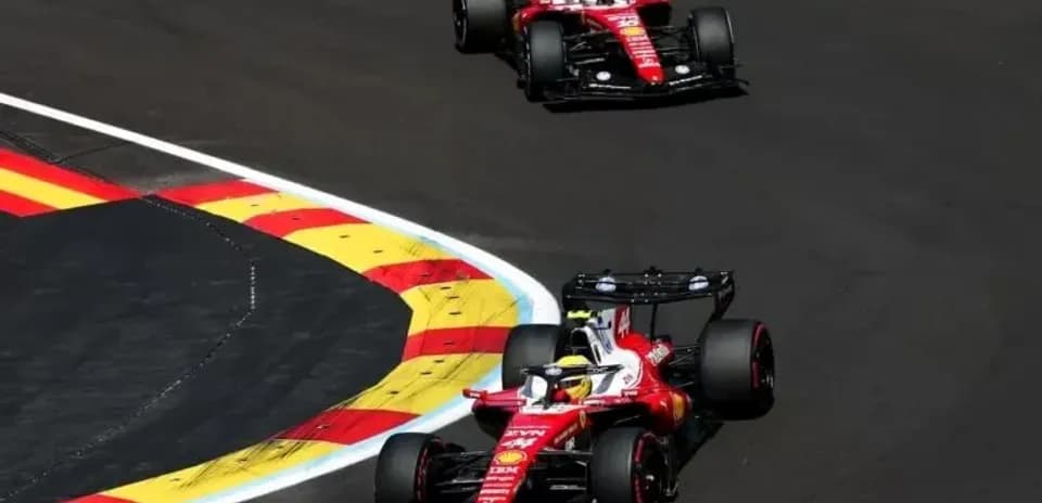 Two Ferrari cars racing on track during event
