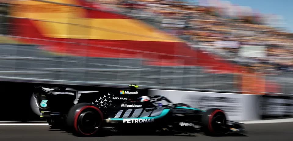 Mercedes car racing past grandstands at event