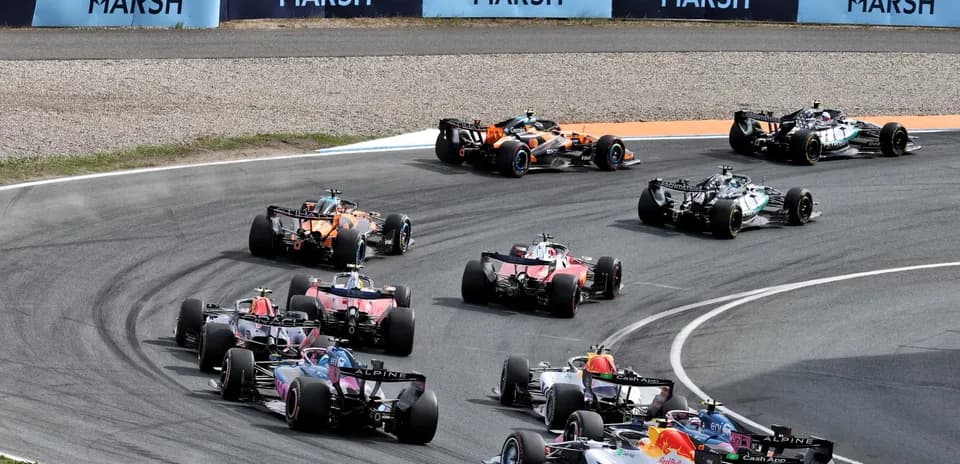Formula 1 cars racing around a corner on track