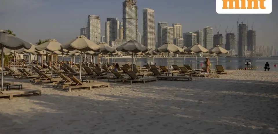 Beach with loungers and city skyline in background