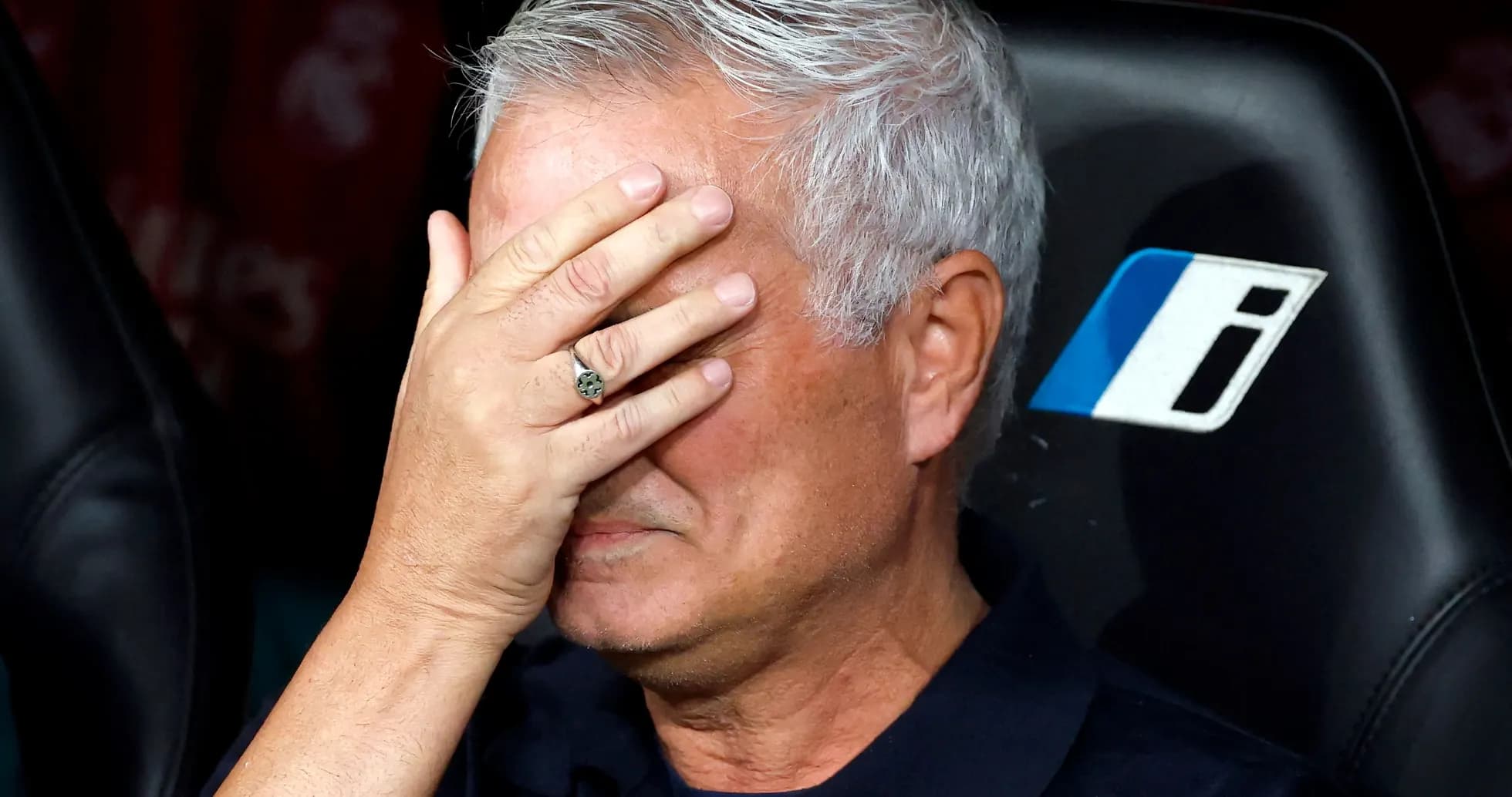 Coach with hand over face on team bench