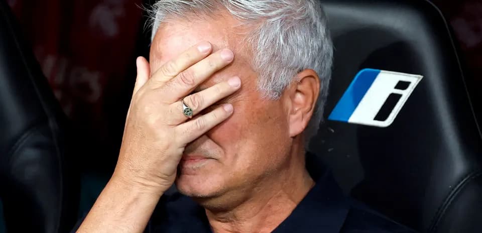 Coach with hand over face on team bench