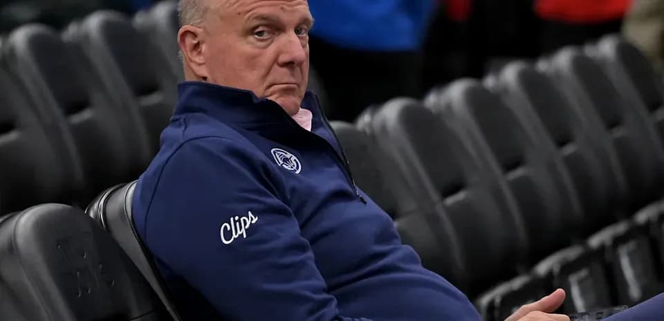 Man sitting in empty arena wearing Clippers attire