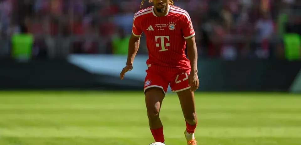 Player in Bayern Munich kit dribbling football on field