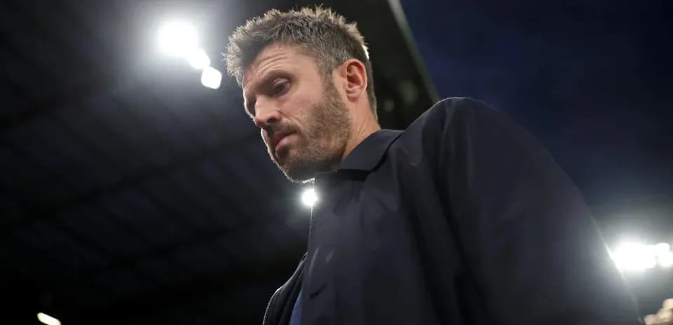 Man in a dark jacket under stadium lights