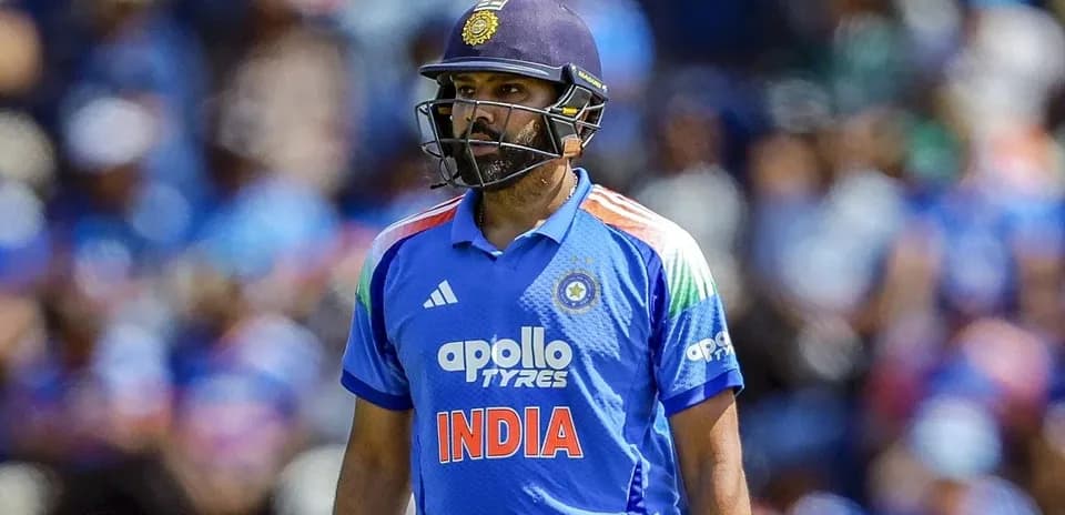 Cricketer in blue jersey walking on field