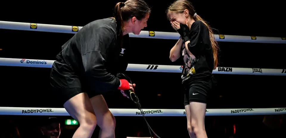 Boxer encouraging young girl in the ring
