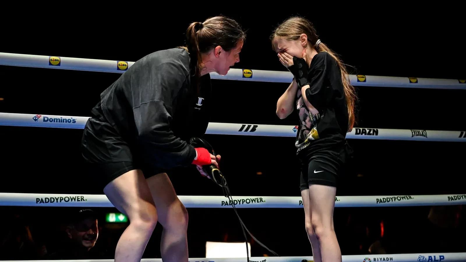 Boxer encouraging young girl in the ring