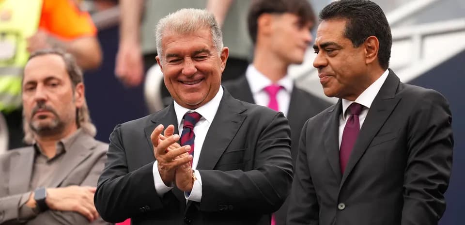 Two men in suits smiling and applauding together