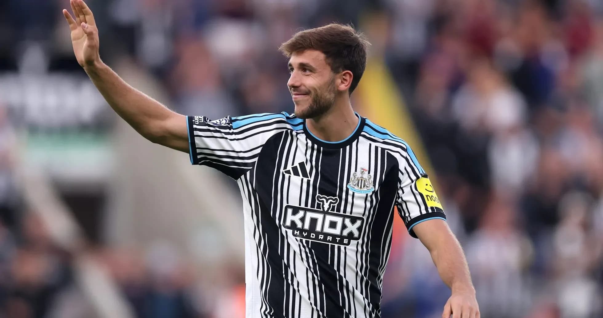 Player waving to fans in Newcastle United jersey