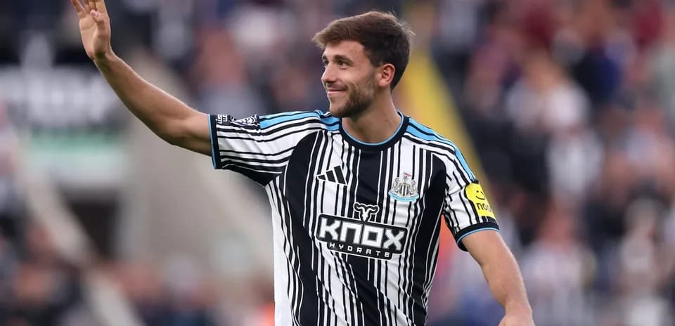 Player waving to fans in Newcastle United jersey