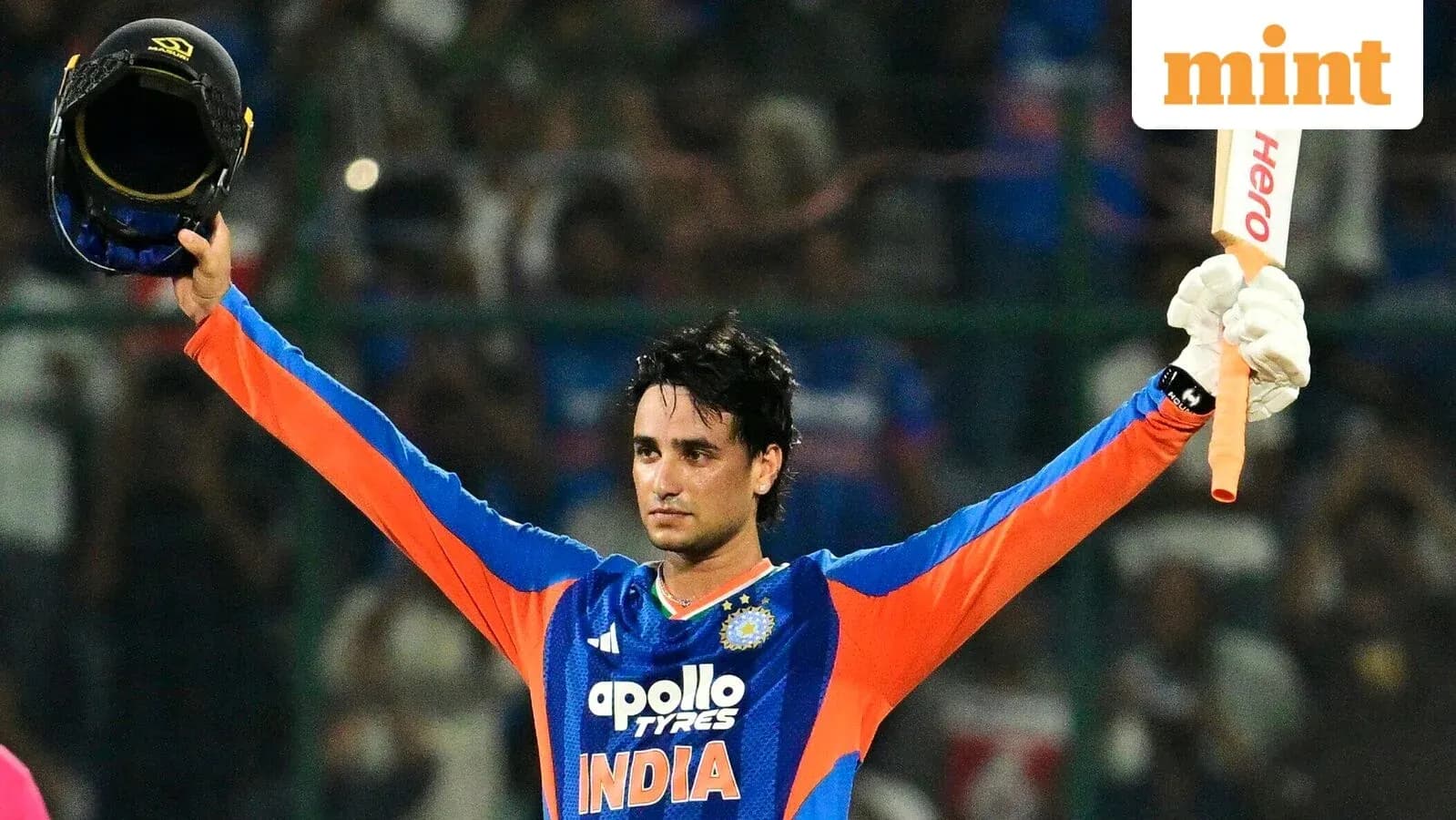 Cricketer celebrating with helmet and bat raised
