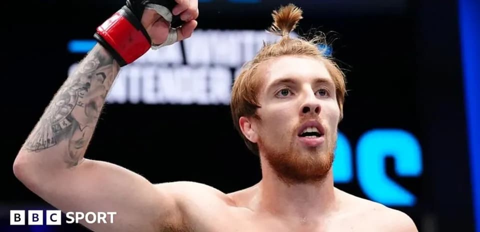 Fighter celebrating victory with raised arm in arena