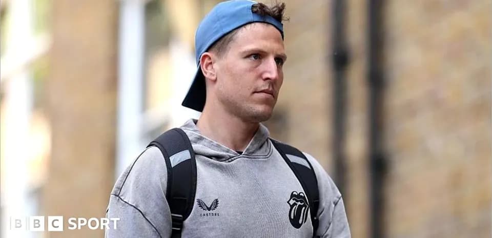 Athlete walking outside wearing a gray hoodie