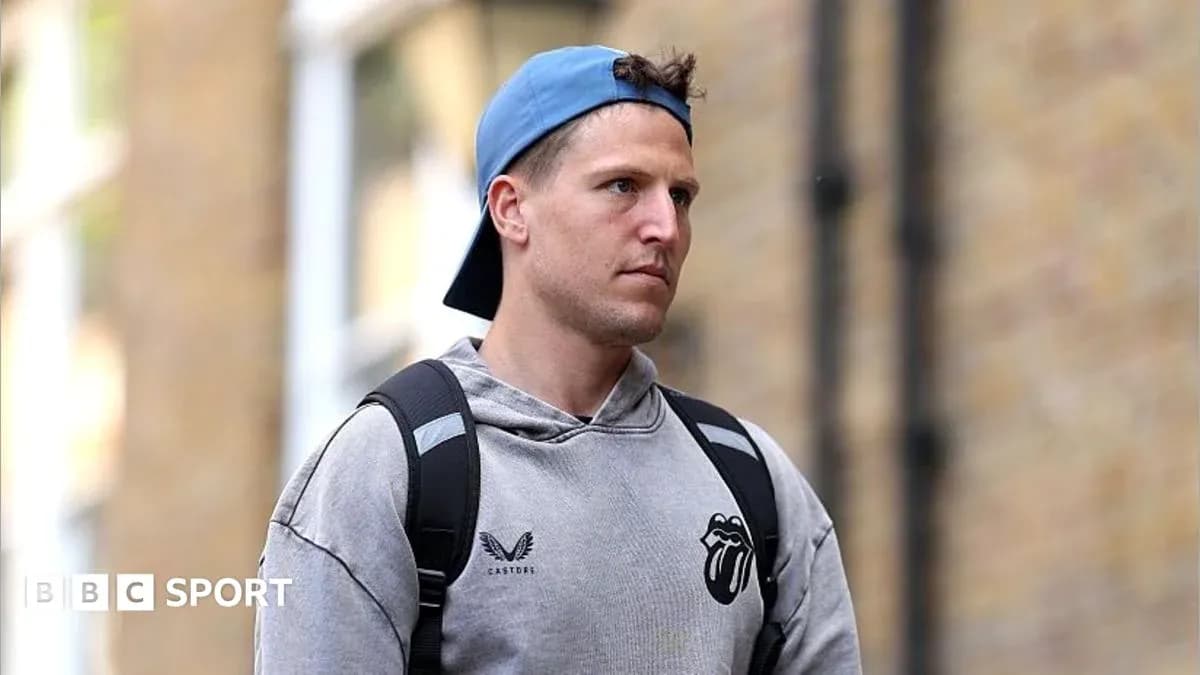 Athlete walking outside wearing a gray hoodie