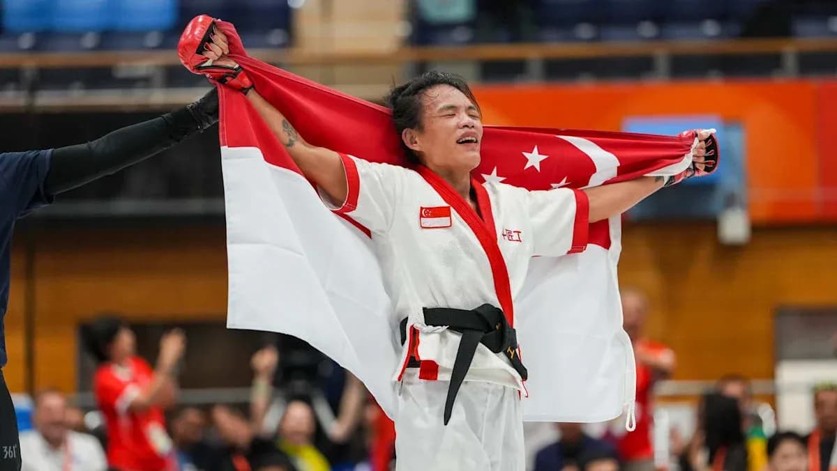 Athlete celebrating with Singapore flag after victory Athlete celebrating with Singapore flag after victory