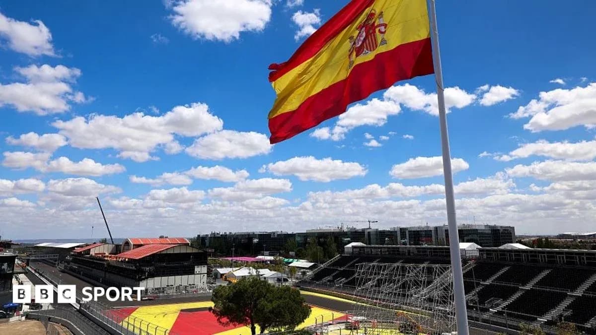 Spanish flag waving over empty racetrack under blue sky Spanish flag waving over empty racetrack under blue sky
