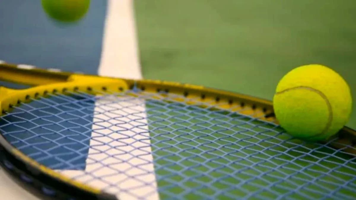 Tennis ball resting on a racket's strings Tennis ball resting on a racket's strings