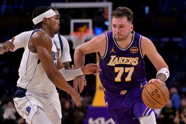 Player dribbling ball while being guarded during game Player dribbling ball while being guarded during game