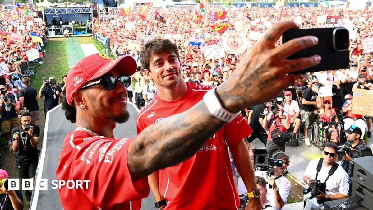 Two drivers taking a selfie with fans in background Two drivers taking a selfie with fans in background
