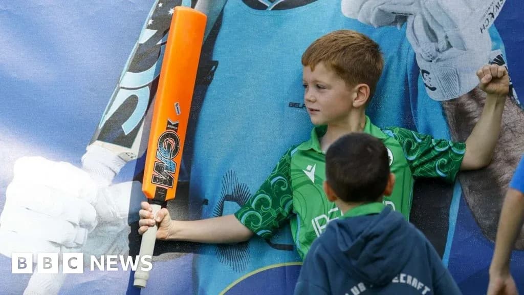 Child posing with cricket bat near poster Child posing with cricket bat near poster