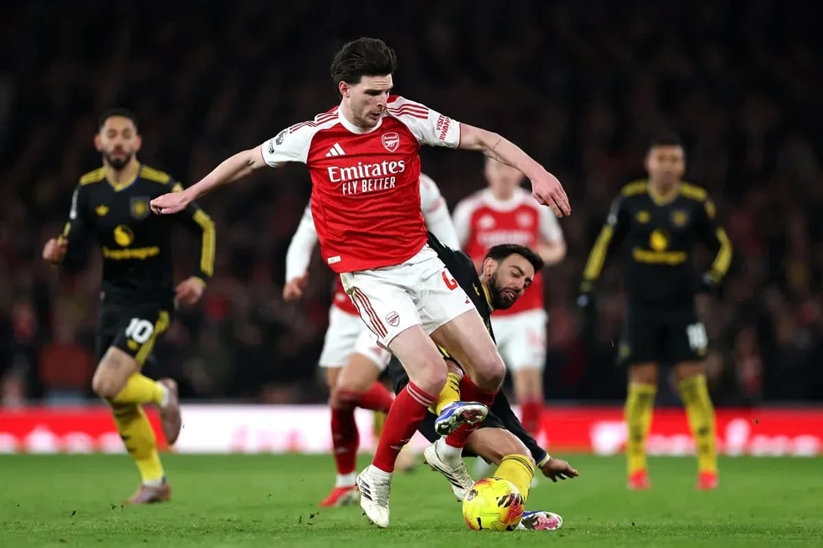 Arsenal player evading a tackle during match Arsenal player evading a tackle during match