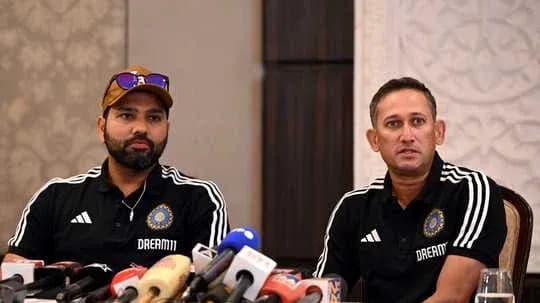 Two cricket coaches at press conference with microphones Two cricket coaches at press conference with microphones