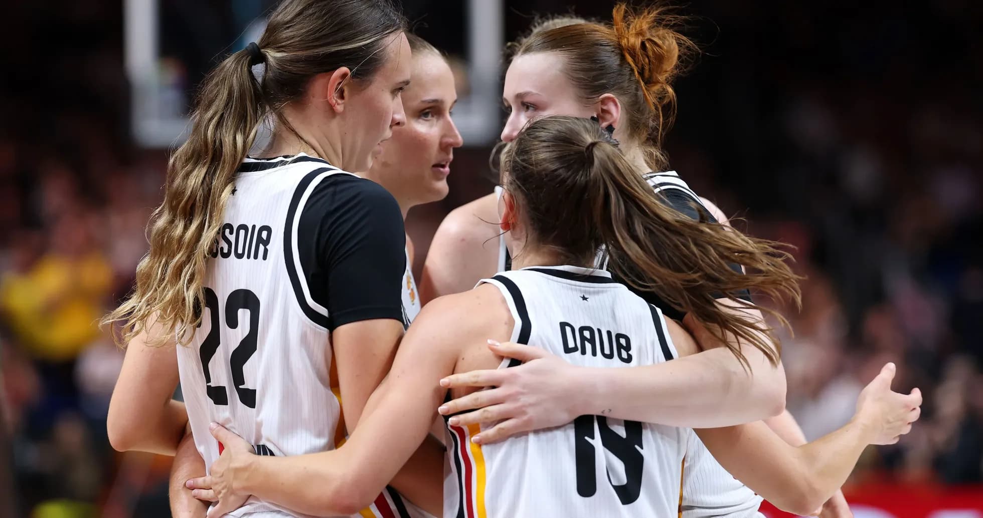 Four basketball players celebrating in team uniforms Four basketball players celebrating in team uniforms