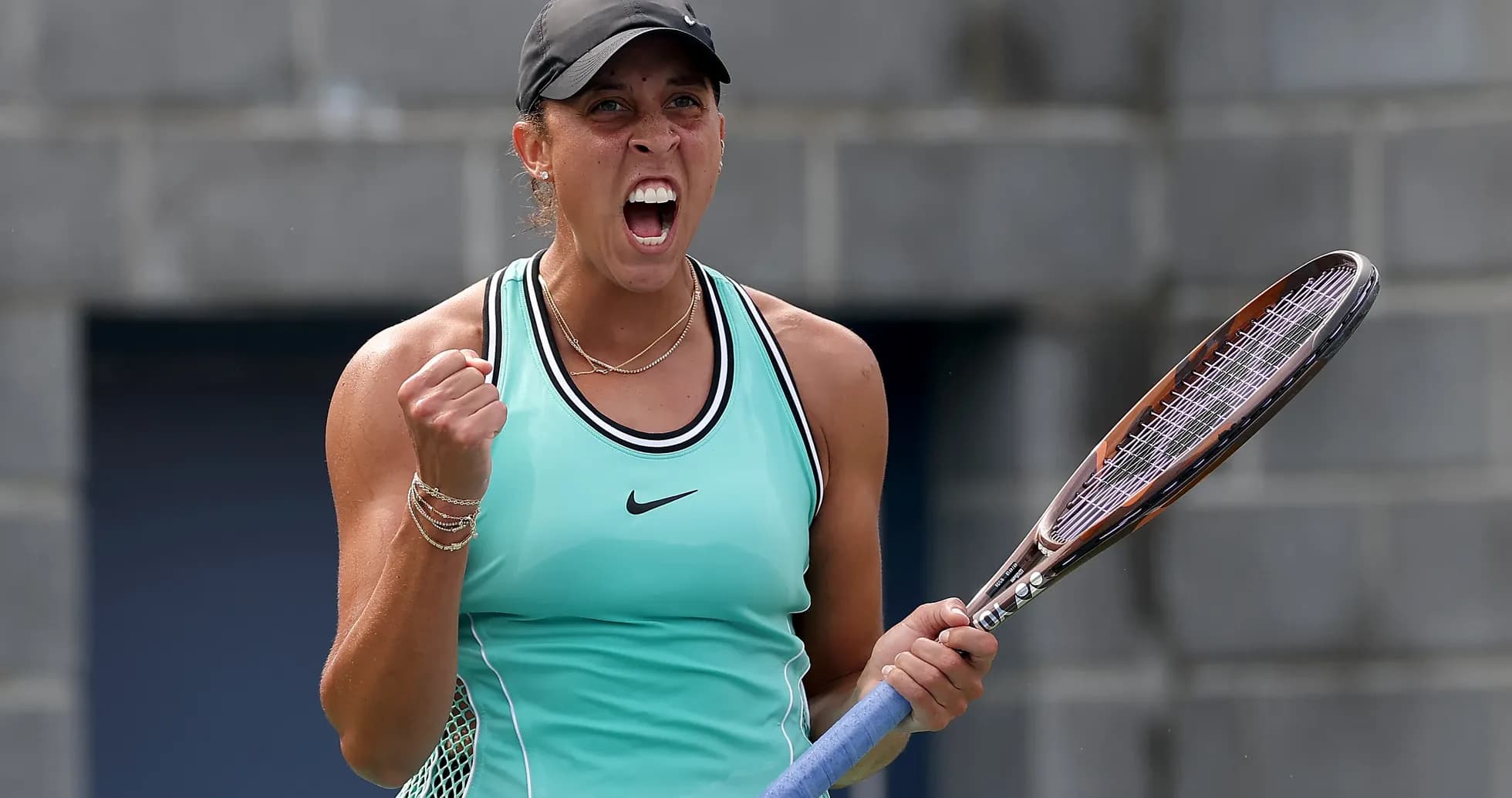 Tennis player celebrating with racket in hand Tennis player celebrating with racket in hand