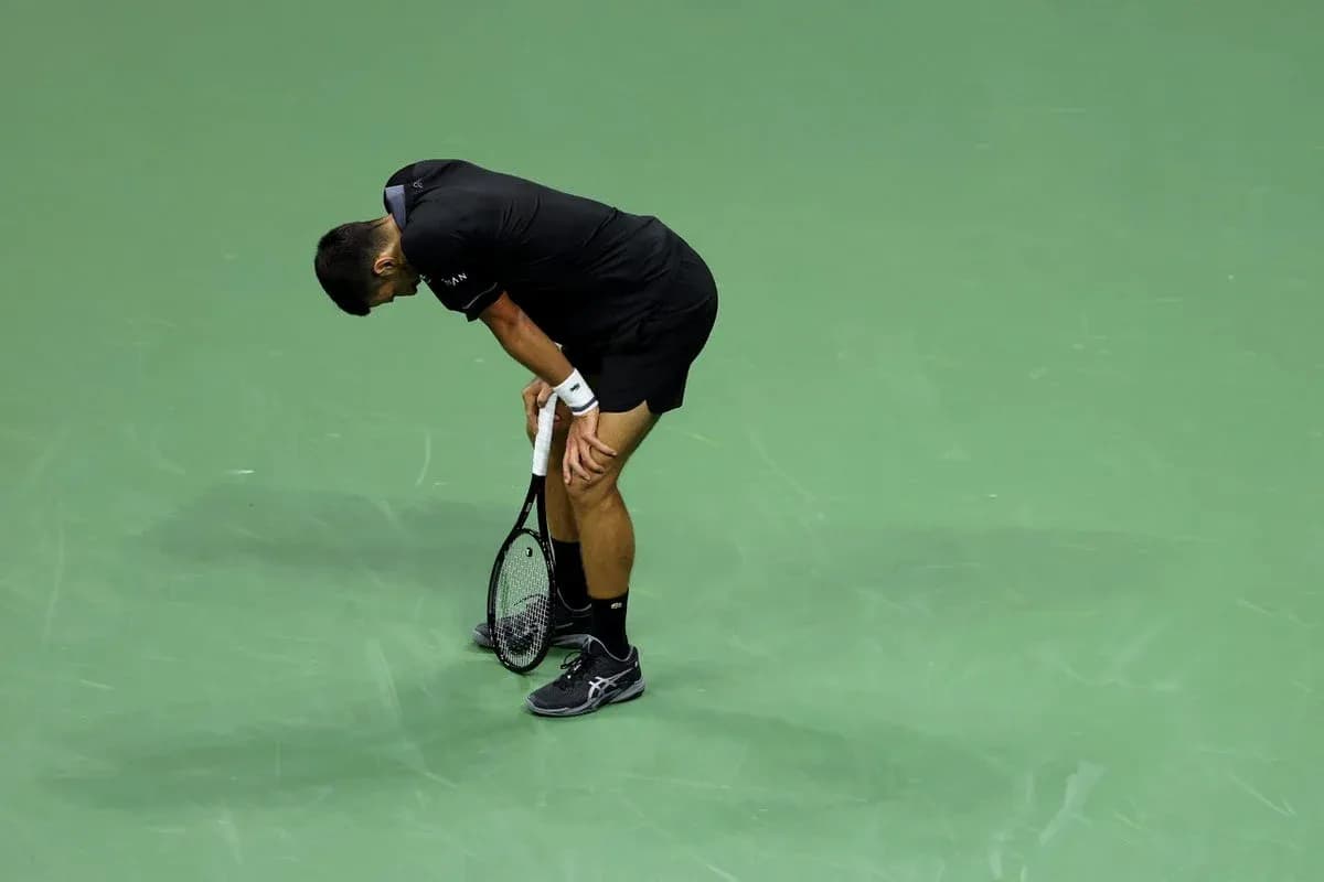 Tennis player bending forward on court during match Tennis player bending forward on court during match