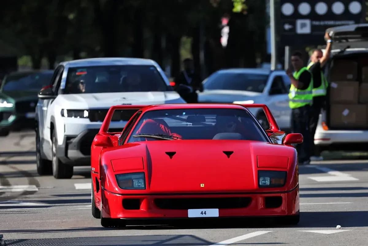 Red sports car driving in busy street traffic Red sports car driving in busy street traffic