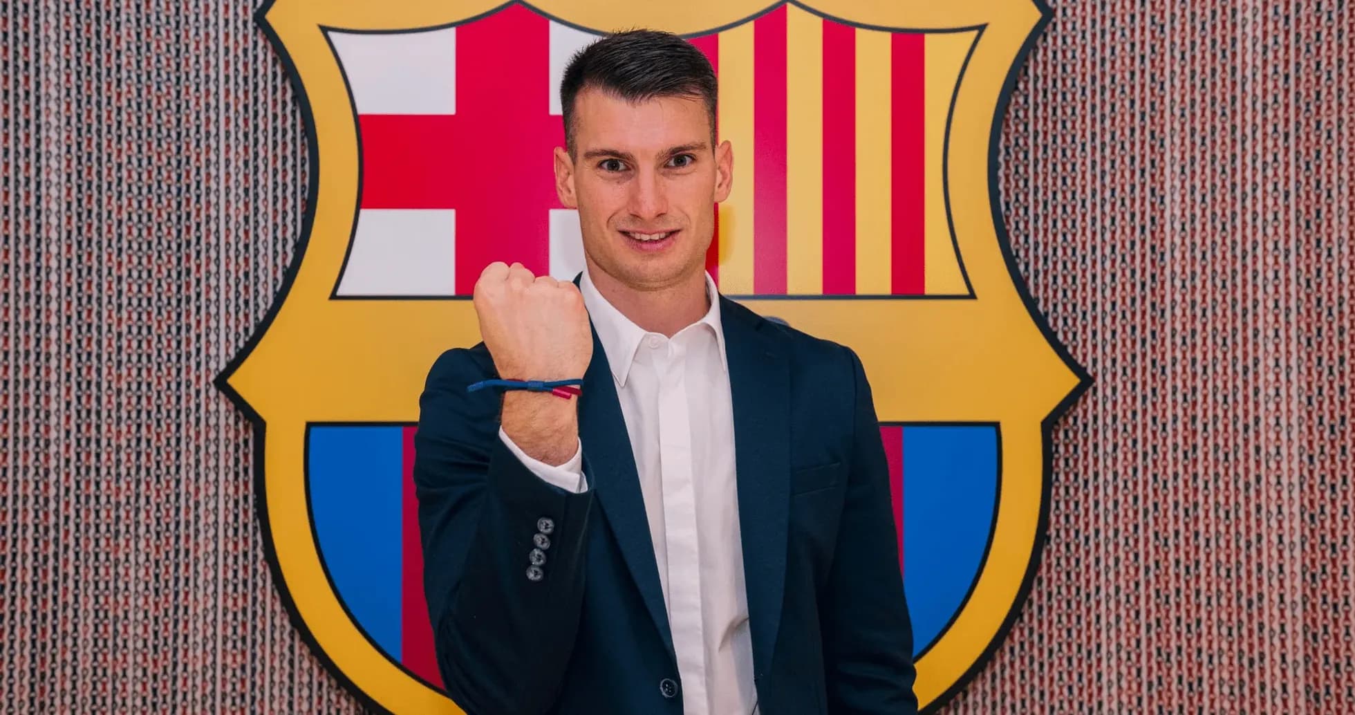 Player posing with fist raised in front of Barcelona logo Player posing with fist raised in front of Barcelona logo