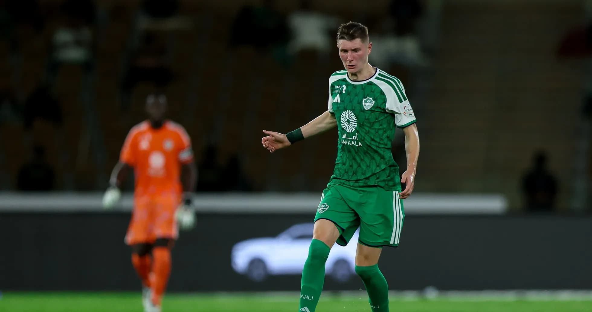 Player in green uniform controlling the ball on field Player in green uniform controlling the ball on field