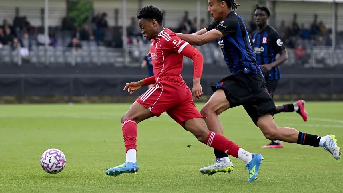 Player in red shirt dribbling past opponent in blue Player in red shirt dribbling past opponent in blue