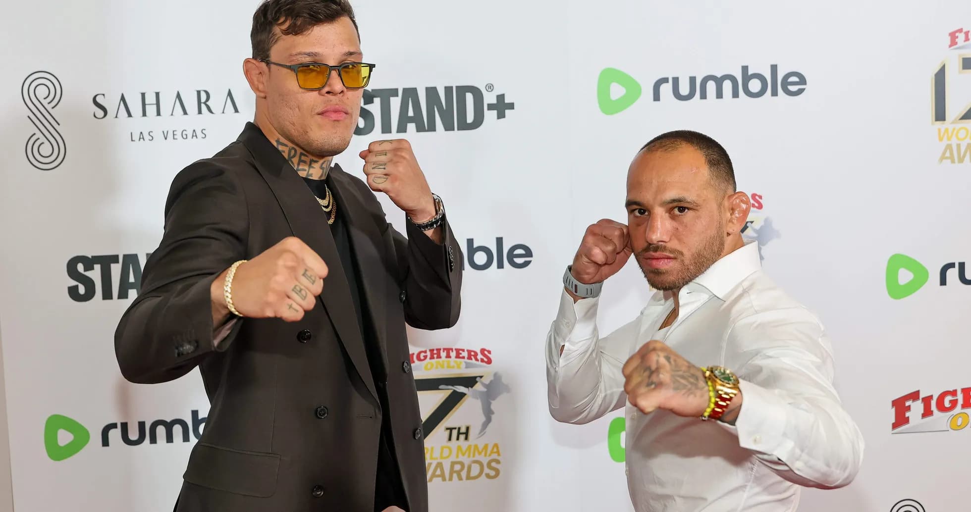 Two fighters posing with fists raised at event Two fighters posing with fists raised at event