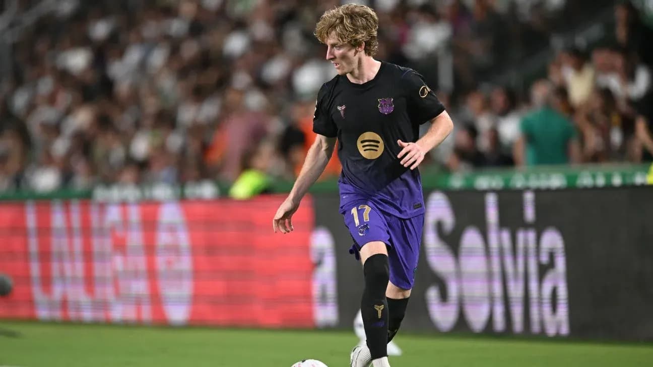 Player in black and purple kit dribbling the ball Player in black and purple kit dribbling the ball