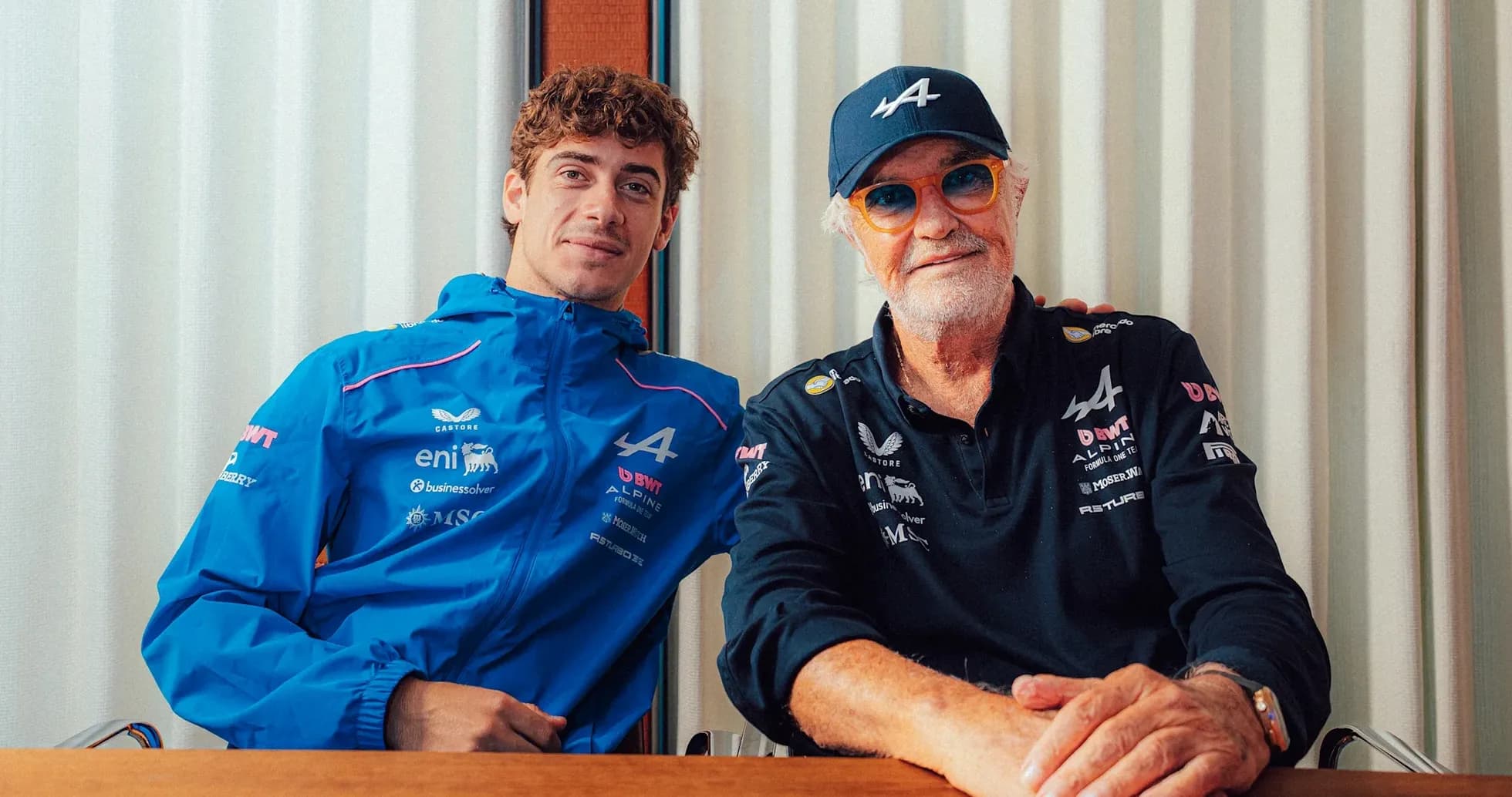Two men posing together, wearing Alpine team apparel Two men posing together, wearing Alpine team apparel