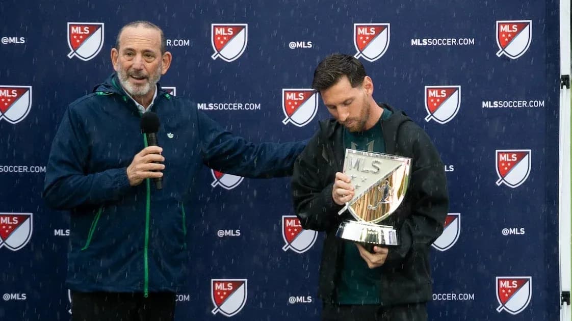 Player receiving trophy during rainy award ceremony Player receiving trophy during rainy award ceremony