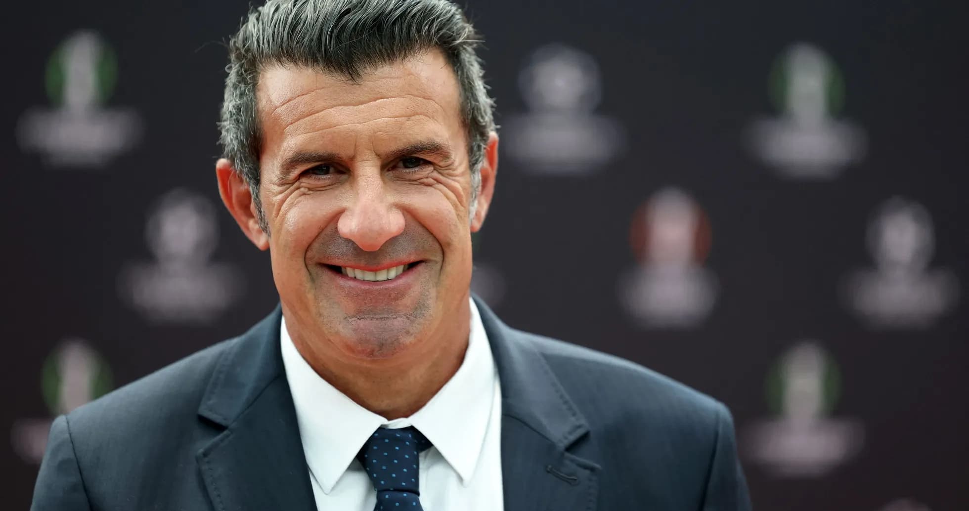 Man smiling in a suit at an event Man smiling in a suit at an event