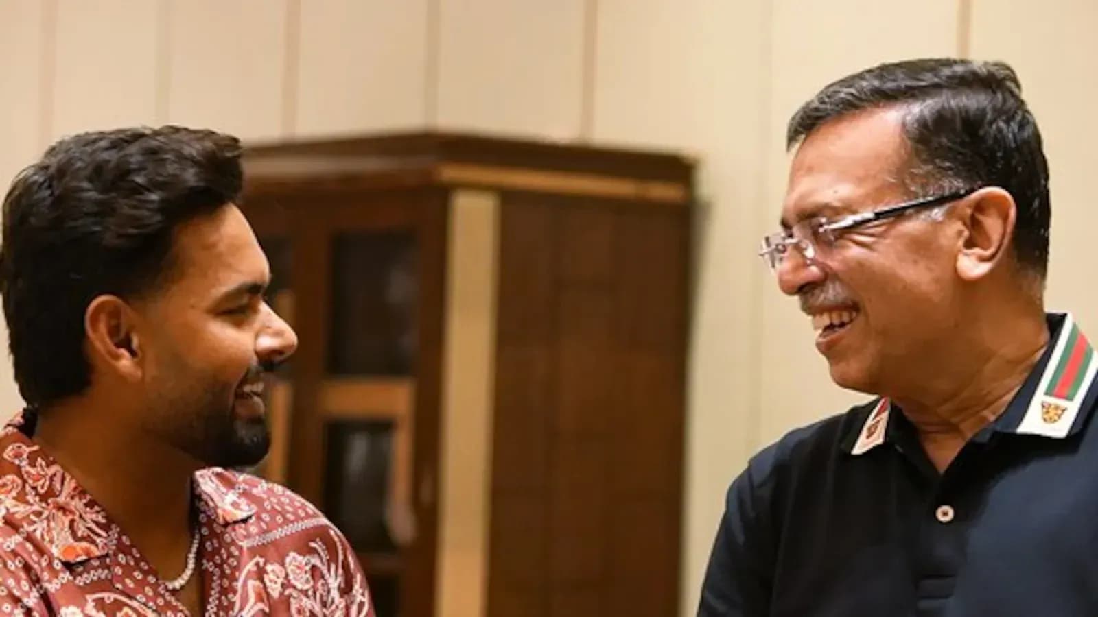 Two men smiling and talking in a room Two men smiling and talking in a room