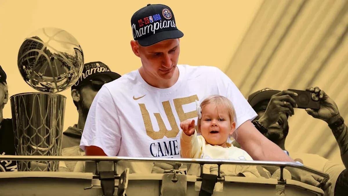 Player holding child during championship celebration parade Player holding child during championship celebration parade