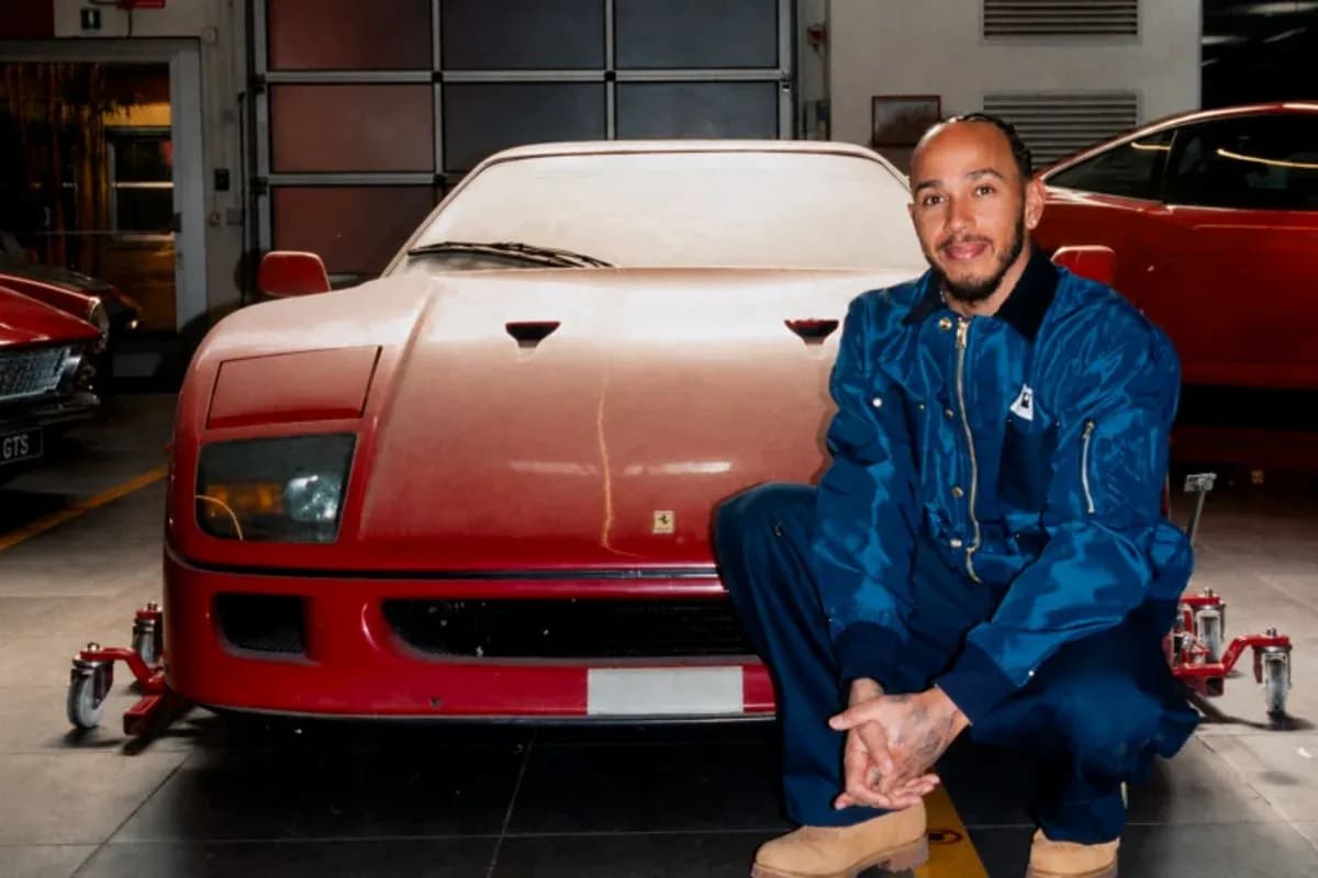 Person kneeling next to a red Ferrari in garage Person kneeling next to a red Ferrari in garage
