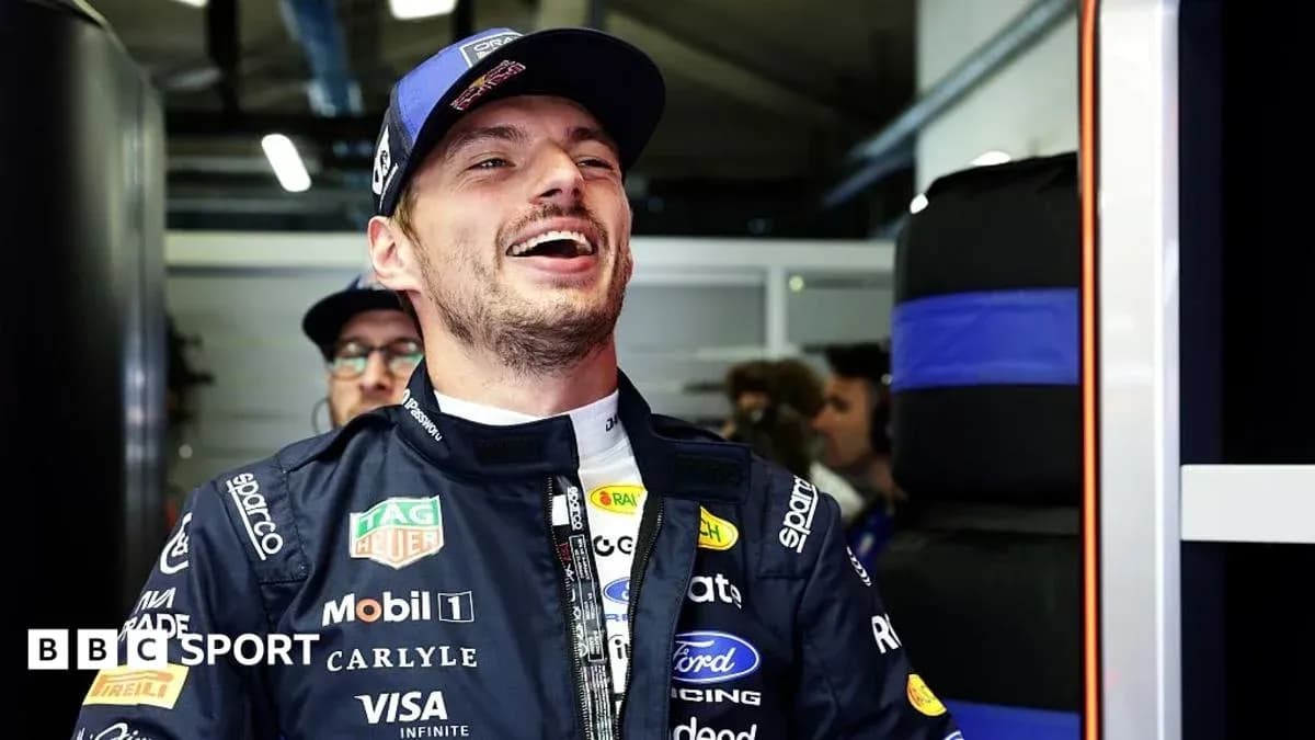 Driver smiling in team garage during event Driver smiling in team garage during event