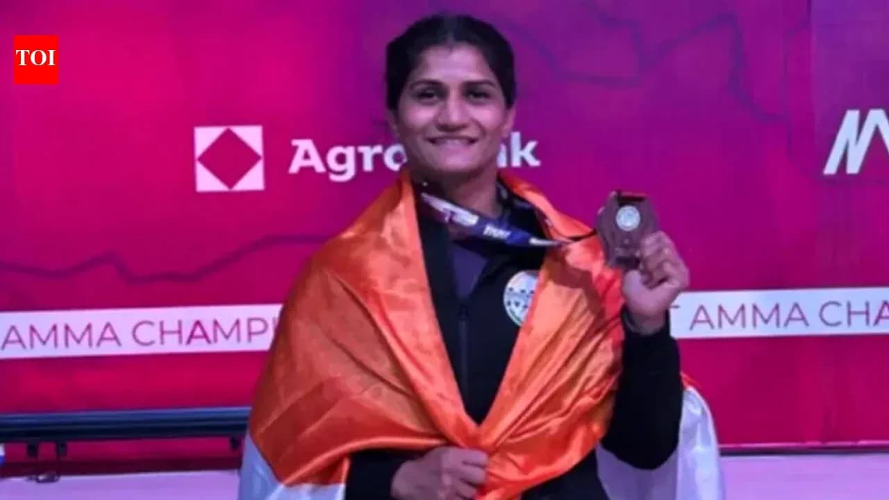 Athlete holding medal, wrapped in Indian flag Athlete holding medal, wrapped in Indian flag
