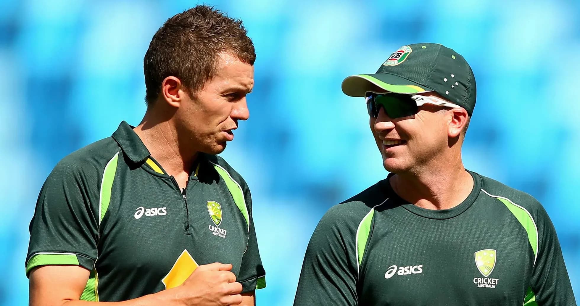 Two Australian cricket players conversing on field Two Australian cricket players conversing on field