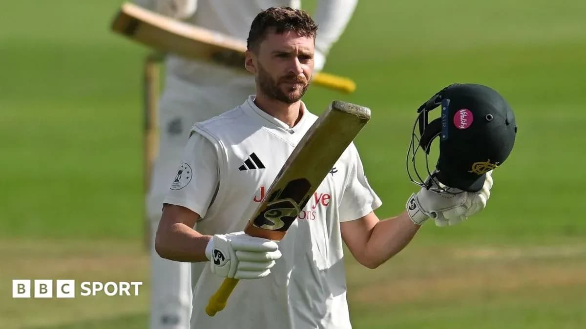 Batsman raising helmet and bat on cricket field Batsman raising helmet and bat on cricket field