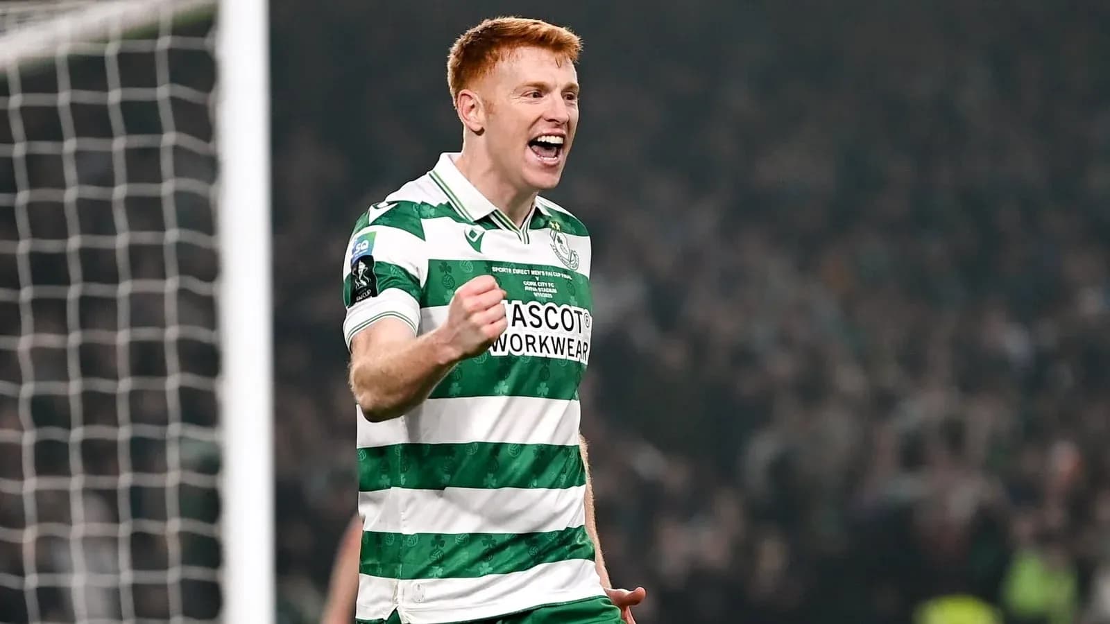 Player celebrating a goal in green and white kit Player celebrating a goal in green and white kit