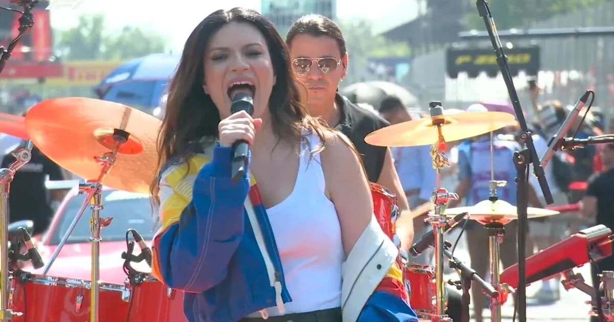 Singer performing on stage with band during event Singer performing on stage with band during event